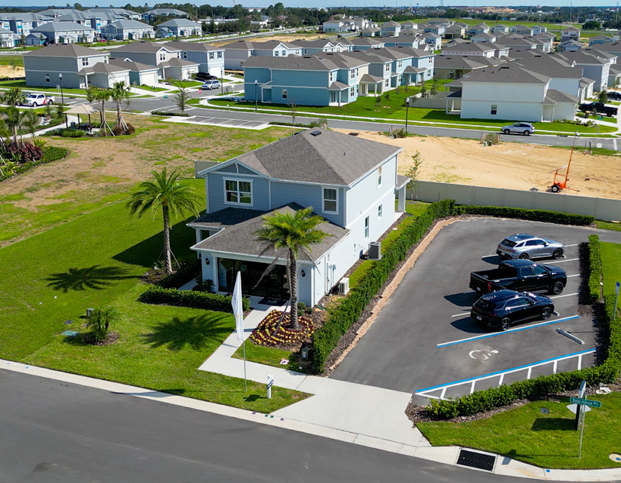 Aerial view of a new construction home in a Florida community, with additional homes and land under development nearby
