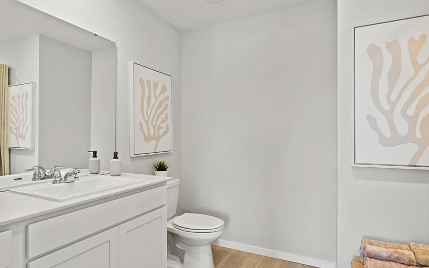 Townhome bathroom with a white vanity, large mirror, and neutral finishes