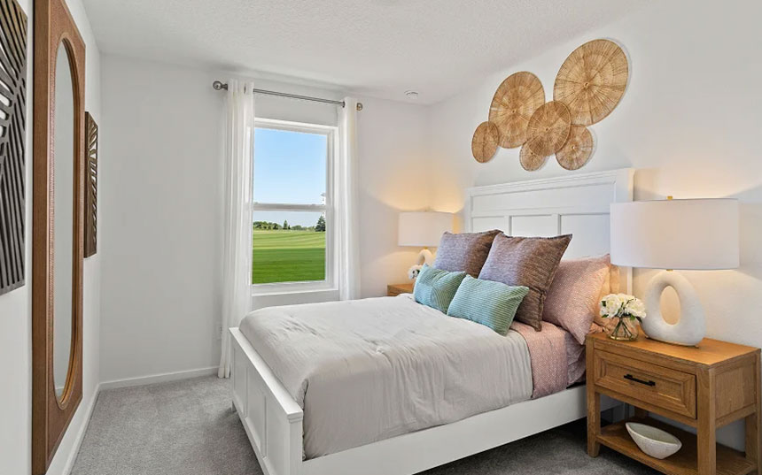Furnished secondary bedroom with a window overlooking the community green space