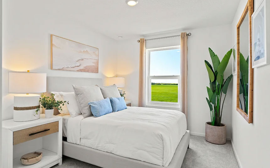 Secondary bedroom with a queen bed, two nightstands, and green-space views