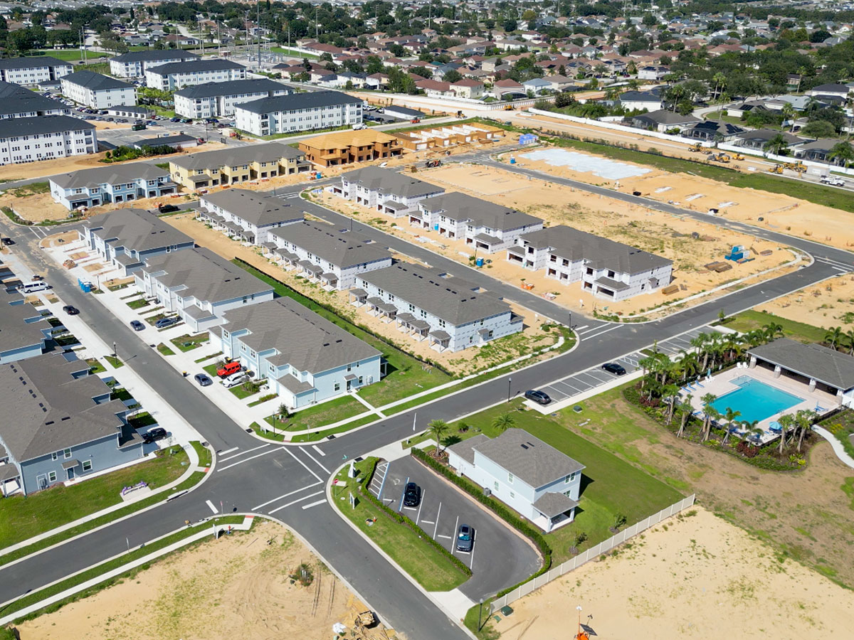 Aerial view of a new construction community in Central Florida with completed homes, a resort-style community pool, and home sites still under development